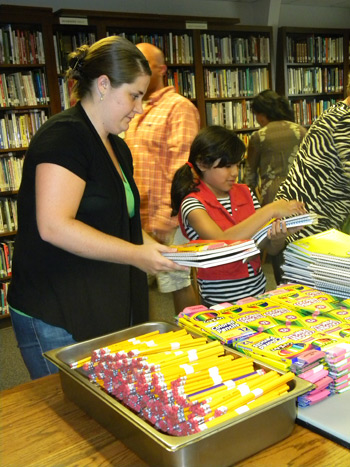 Peyton Erb (left) works in the assembly line putting MCC school kits together. Photos courtesy of authors