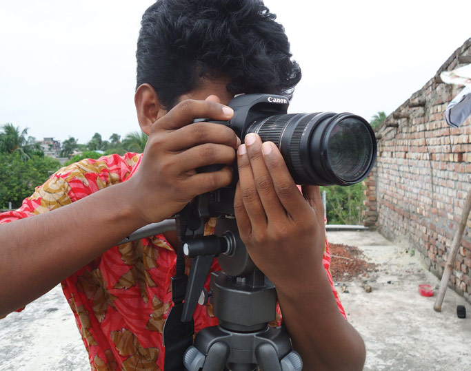 A young man in the community takes images for a new multimedia business. Courtesy photo.