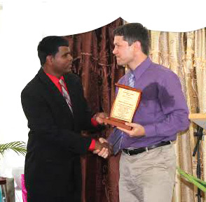 Deolal Ramdial, MCTT president, presents a token to Aaron Kauffman, president of VMMissions, during the 40th anniversary celebrations. Courtesy photo