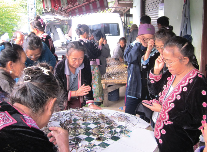 Gli abitanti del villaggio Hmong smistano le pile di occhiali donati da una sezione del Lion's Club della Carolina del Nord. Foto: Giona Yang