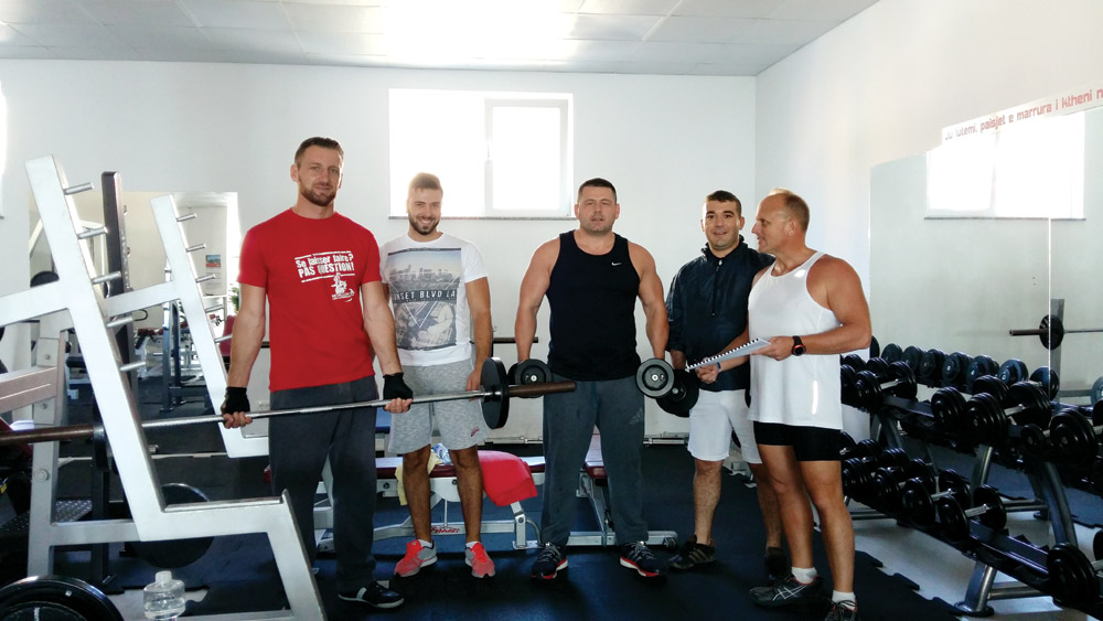 (From left) Granit, Bledor, Bek, Valdet and author Vince at the fitness center. Vince is holding his training schedule.  Photo courtesy of author