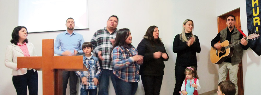 Leading worship at the Guri I Themelit church: Solange and Rafael Tartari (left) sing in praise together with lay members of the church and fellow mission workers Juliana and Francis Marques (right). Photo by Richard Bowman