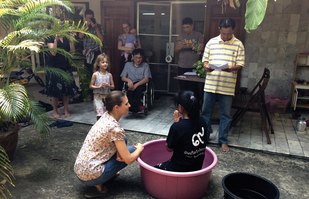 The baptism of P Jan, with P Jaa officiating, and local partners Khun Koch (seated) and P Ehk (standing) joining in the celebration. Also pictured is the author (kneeling), her husband Steve Horst and their two children, and Jessamyn Tobin. Photo by Lynn Suter