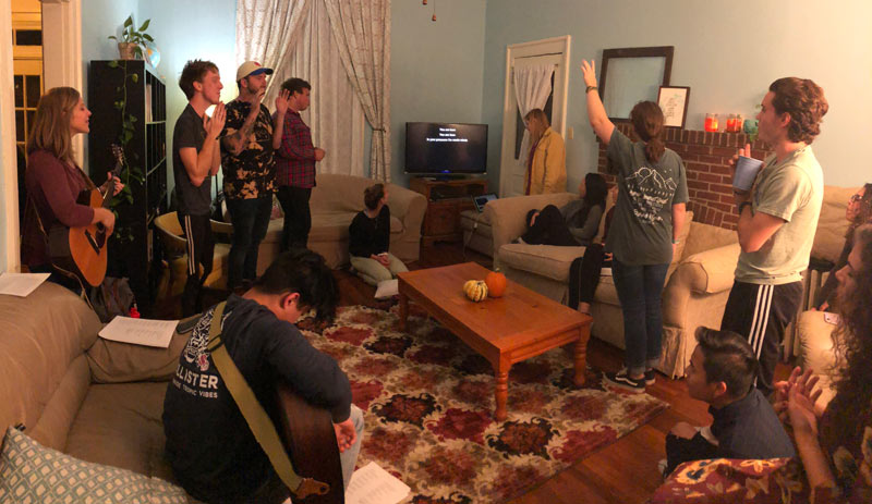 College students worship in the living room of 264 OSH, a hospitality ministry called Eastside College that invites students into a growing relationship with God.