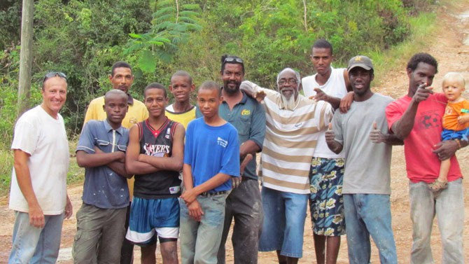 Rodney Knepp (l) with older boys from the school and local men who spent a morning patching a road. Micah Knepp is on the right, held by Keron. Courtesy of author