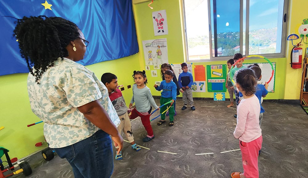 Norma leads children at the Joshua Center in a cooperative activity. Photo by Tom Yoder